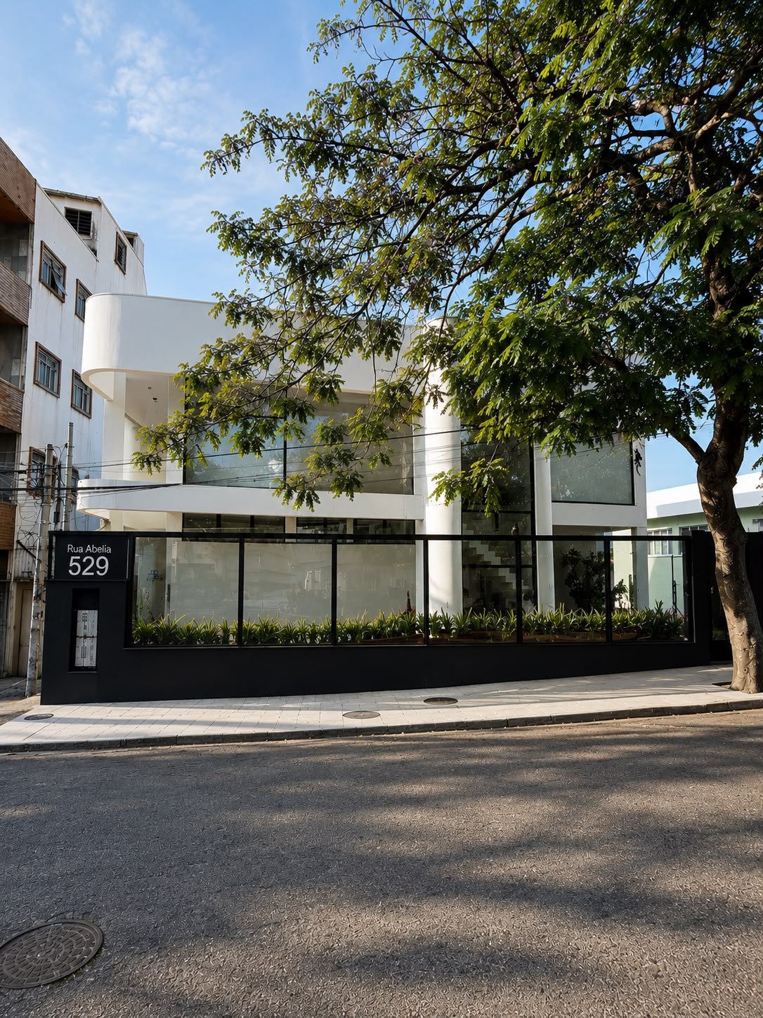 Fachada da L. Clinic na Rua Abélia, 529, com árvore e jardim em frente